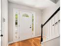 Bright foyer with hardwood floors, white door with sidelights, and staircase at 3956 Church View Ln, Suwanee, GA 30024