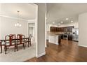 Bright dining room seamlessly connects to a kitchen with stainless steel appliances and dark wood cabinets at 11973 Lovejoy Crossing Way, Hampton, GA 30228