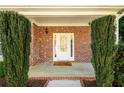 A charming front porch featuring brick accents, manicured bushes, and a welcoming front door at 742 Hope Hollow Ln, Loganville, GA 30052