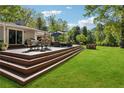 Outdoor dining on a multi-tiered deck, with ample seating and scenic views of the lush backyard at 1155 Christian Se Cir, Conyers, GA 30013