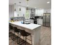 This well-lit kitchen features white cabinets, stainless steel appliances, a center island with seating, and wood flooring at 1155 Christian Se Cir, Conyers, GA 30013