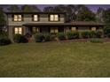 Charming two-story home with a covered front porch and well-maintained landscaping at twilight at 1757 Colonial South Sw Dr, Conyers, GA 30094
