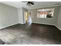 Living room with hardwood floors, ceiling fan, and view into the kitchen at 4645 Valais Ct # 121, Alpharetta, GA 30022