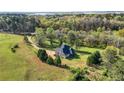 Peaceful aerial view of a two-story home with a lush green lawn, mature trees, and a charming fenced yard at 240 Indian Creek Rd, Locust Grove, GA 30248