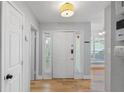 Bright entryway featuring hardwood floors, a white front door with sidelights, and a view into the adjacent living spaces at 6810-G Glenridge Dr, Atlanta, GA 30328