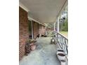 View of a covered porch with potted plants and brick facade, perfect for outdoor enjoyment at 6957 Mason Creek Rd, Douglasville, GA 30135