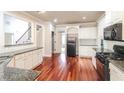 Kitchen featuring hardwood floors, granite counters, with stairs and doorway visible at 1209 Richmond Rdg, Loganville, GA 30052
