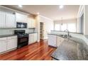 Bright kitchen boasts hardwood floors, granite counters, and modern white cabinets at 1209 Richmond Rdg, Loganville, GA 30052