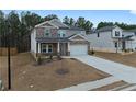 Two-story home featuring a stone and siding facade, a two-car garage, and a neatly landscaped front yard at 4171 Dean Grove Way, Loganville, GA 30052