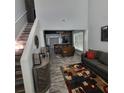 Open-concept living room featuring hardwood floors, high ceilings, natural light, modern decor, and seamless flow into dining area at 1503 Korona Ct, Woodstock, GA 30188