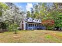 Charming two-story home with front porch, mature trees, and landscaped front yard at 2425 Shiloh Sw Dr, Marietta, GA 30064