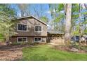 Traditional-style home with a manicured lawn and a covered front porch, nestled amongst mature trees at 250 Martin Ridge Ct, Roswell, GA 30076