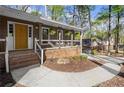 Charming front porch with brick steps, a bright yellow door, and hanging plants creating a welcoming entrance at 250 Martin Ridge Ct, Roswell, GA 30076