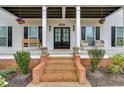 Inviting front porch with double doors, a sitting bench, and black shuttered windows at 3642 Falls Trl, Winston, GA 30187