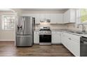 Well-equipped kitchen with stainless steel appliances, white cabinets, and elegant countertops, perfect for cooking at 1248 Falling Water Se Dr, Smyrna, GA 30080