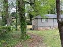 View of the backyard showing the home's exterior and surrounding trees, and landscaped features at 4632 Burks Rd, Forest Park, GA 30297