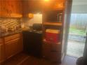 Compact kitchen with dark countertop, wooden cabinets, and an exterior door at 4632 Burks Rd, Forest Park, GA 30297