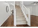 Interior view of staircase featuring wood floors, white railing, and access to the kitchen at 995 Litchfield Pl, Roswell, GA 30076
