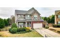 Charming two-story home features a stone and brick facade, two-car garage and welcoming front yard at 6675 Flagstone Ct, Cumming, GA 30028