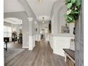 Bright and airy foyer with hardwood floors, elegant archways, and modern lighting fixtures at 6675 Flagstone Ct, Cumming, GA 30028