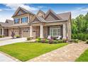 Charming exterior view of home featuring a well-maintained lawn, brick and siding accents, and attached garage at 2940 W Village Dr # 60, Suwanee, GA 30024