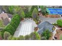 Aerial view of community pool and amenity area including playground, tennis and basketball courts surrounded by mature trees at 10460 Cranchester Way, Alpharetta, GA 30022