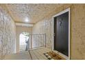 Hallway featuring a black door, a welcome mat, and an archway leading to stairs at 3155 Seven Pines Ct # 303, Atlanta, GA 30339