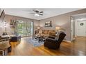 Living room featuring hardwood floors, ceiling fan, a brown sofa and access to a patio at 3155 Seven Pines Ct # 303, Atlanta, GA 30339