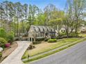 Aerial view of home with driveway, large lawn, mature trees and well-maintained landscape at 4062 Silver Fir Ct, Marietta, GA 30066