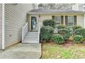 Inviting front entrance with a decorative door and landscaped bushes at 5880 April Dr, Sugar Hill, GA 30518