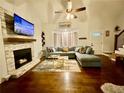 Bright living room featuring hardwood floors, a stone fireplace, and a comfortable sectional sofa at 1118 Magnolia Se Way, Smyrna, GA 30082