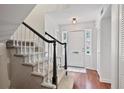 Welcoming foyer with hardwood floors, coat closet, and staircase with dark wood banister and plush carpeting at 4620 Wieuca Ne Rd # 24, Atlanta, GA 30342