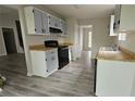 Galley kitchen featuring gray cabinets, black appliances, and laminate flooring at 890 Shiloh Ridge Nw Run, Kennesaw, GA 30144