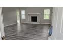 Spacious living room featuring a fireplace, large windows, and modern gray laminate flooring at 890 Shiloh Ridge Nw Run, Kennesaw, GA 30144