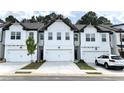 New townhomes with a modern farmhouse exterior feature two-car garages and ample parking at 421 Auburn Valley Way, Auburn, GA 30011