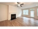 Bright living room with hardwood floors, a fireplace, and a ceiling fan at 421 Auburn Valley Way, Auburn, GA 30011