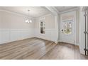 Elegant dining room featuring hardwood floors, wainscoting, and modern chandelier at 4229 Brookmont Way, Auburn, GA 30011