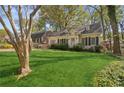 Beautifully landscaped front yard of a light brick house, featuring manicured shrubs and mature trees at 28 Exeter Rd, Avondale Estates, GA 30002