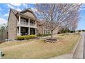 Beautiful brick home with a covered porch, lush green lawn, and attractive landscaping at 2875 Waterstone Dr, Cumming, GA 30041
