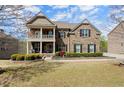 Charming brick home featuring a covered porch, well-manicured landscaping, and inviting curb appeal at 2875 Waterstone Dr, Cumming, GA 30041