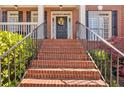 Welcoming front entrance with a brick staircase, black door with wreath, and manicured landscaping at 3509 Ivy Manor Se Rd, Smyrna, GA 30080