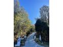 Long concrete driveway flanked by landscaping and trees at 4748 Arcado Sw Rd, Lilburn, GA 30047