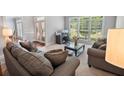 Bright living room with large windows, neutral carpet, and comfortable seating area at 5101 Barrington Trace Dr, Atlanta, GA 30331