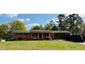 Attractive one-story brick home featuring flowering bushes, front porch, and side carport at 4172 N Martin Way, Lithia Springs, GA 30122