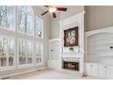Bright living room with a fireplace, built-in shelves, and large windows offering scenic views at 4847 Sara Creek Way, Sugar Hill, GA 30518
