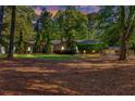 The home's front lawn is shaded by mature trees and includes a trimmed evergreen landscape and a side-entry garage at 2701 East Mill Sw Way, Conyers, GA 30094