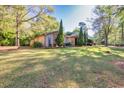 A lush green lawn and mature trees add curb appeal to this home with an evergreen-landscaped front yard at 2701 East Mill Sw Way, Conyers, GA 30094