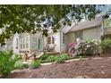 Beautiful white brick home with a stone walkway, blooming azalea bushes, and exterior staircase with chairs at 1794 Charline Ne Ave, Atlanta, GA 30306