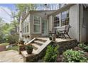 Lovely white brick home with exterior chairs, stone staircase, and lush foliage on a sunny day at 1794 Charline Ne Ave, Atlanta, GA 30306