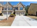 Charming brick townhome featuring an attached two-car garage and manicured front yard at 6160 Shiloh Woods Dr, Cumming, GA 30040